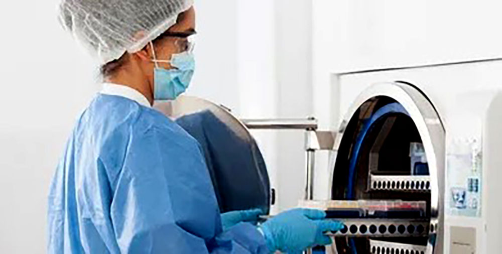 خانومی که در حال کار کردن با دستگاه اتوکلاو مناسب آزمایشگاه است